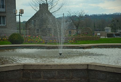 Fountain with water splashing at main square in Sourdeval France