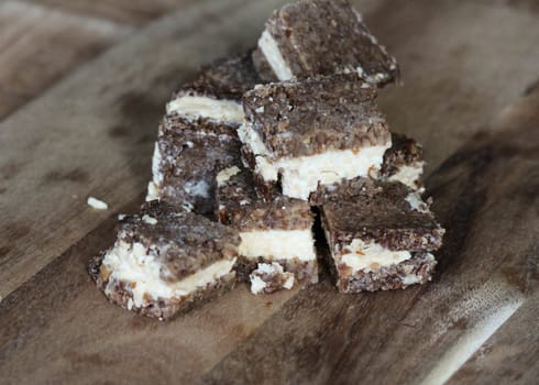close up of rye bread with aged cheese on wooden background