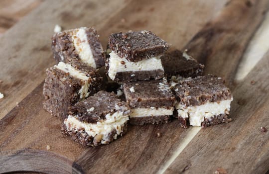 close up of rye bread with aged cheese on wooden background