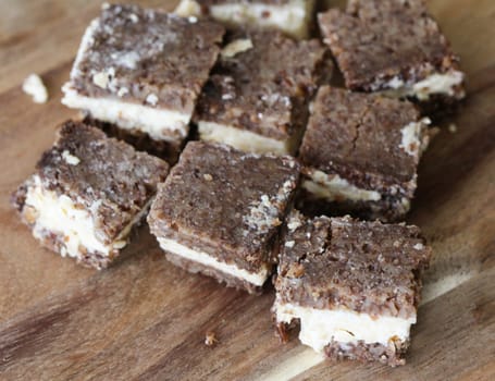 close up of rye bread with aged cheese on wooden background