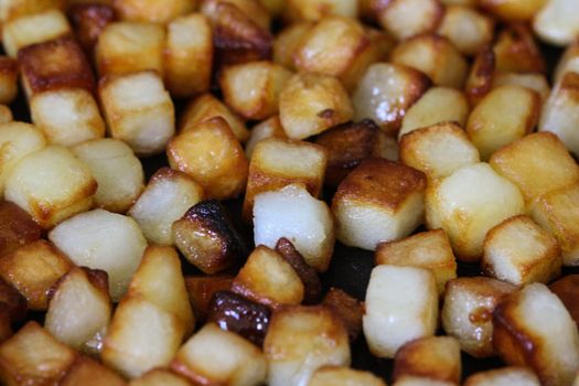 close up of baked potato cubes in pan in kitchen
