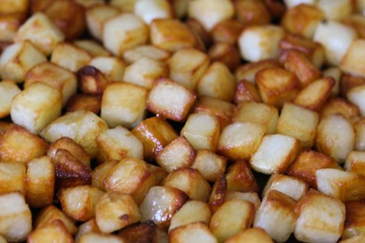 close up of baked potato cubes in pan in kitchen