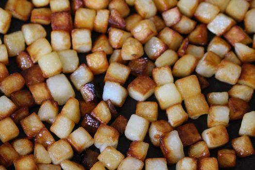 close up of baked potato cubes in pan in kitchen