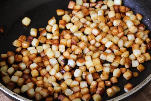 close up of baked potato cubes in pan in kitchen
