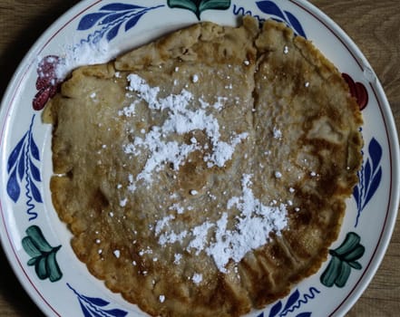 close up of pancake with powdered sugar