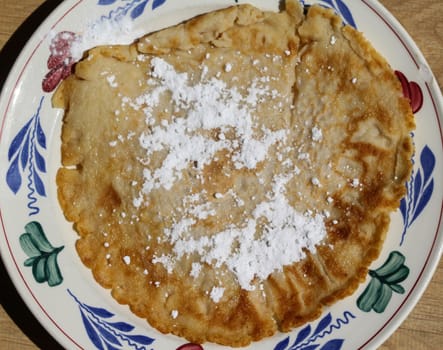 close up of pancake with powdered sugar