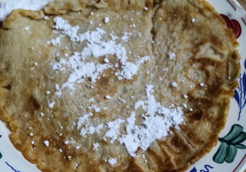 close up of pancake with powdered sugar