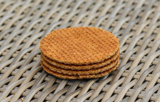 close up of stack of traditional dutch stroopwafels cookie, a caramel syrup waffle, on wooden background
