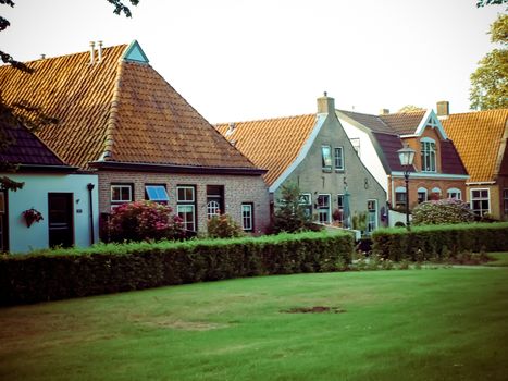 Modern row houses with brown bricks and red roof tiles in Netherlands