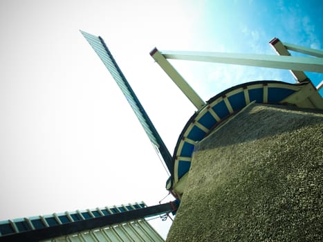 View of a windmill from the bottom up to the wings and sky