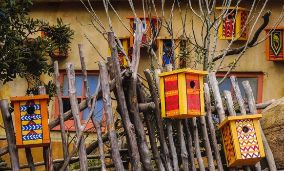Several bird houses painted in vibrant colours