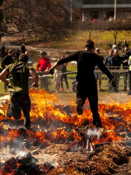 Two guys jumping over fire in a race