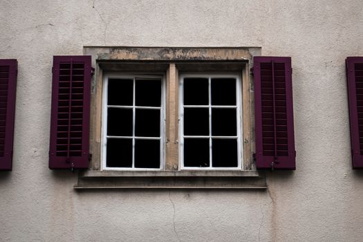 Beautiful purple window shutters on a white wall