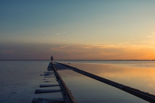 Woman at beauty sunset on salty lake