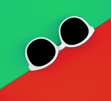 Sunny stylish white sunglasses on a bright green-cyan and red-orange background, top view, isolated. Copy space. Flat lay.