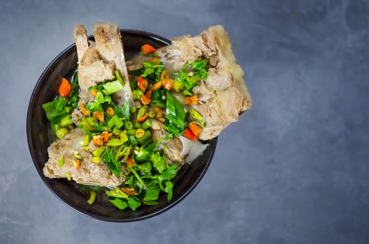 pork bone with chili and vegetables spicy and sour soup  in black bowl , ( Leng soup )