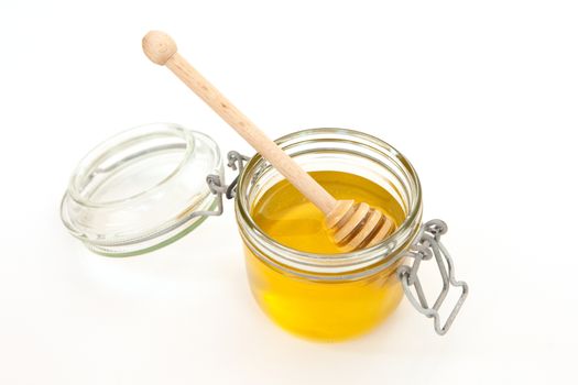 Honey jar with a wooden stick for honey on white background. Concept of healthy food. Honey like superfood. Minimalism style.