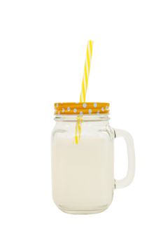 Mason jar with striped plastic tube with milk isolated on white background. Concept of World Milk Day, proper healthy nutrition. Side view. Object to use in book or social media layout. Vertical.