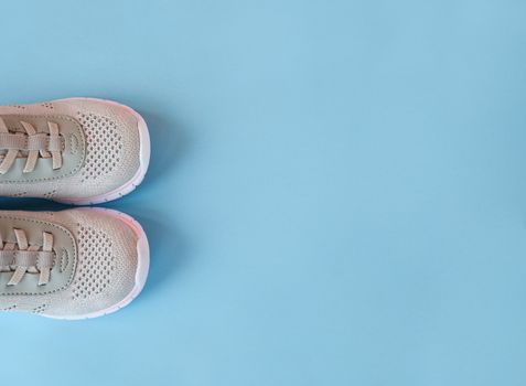 Sport, healthy lifestyle concept. New gray sneakers on pastel blue background. Copy space. Flat lay.