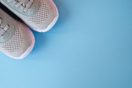 Sport, healthy lifestyle concept. New gray sneakers on pastel blue background. Copy space. Flat lay.