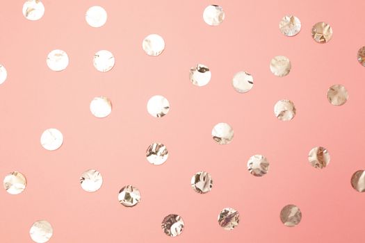 Pattern of shiny silver confetti on pastel millennial pink paper background. Concept of holiday, birthday, blogging, beauty. Top view. Flat lay. Minimal style mock up. Template for blog. Copy space.