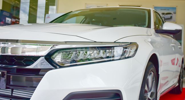 Close up shot of headlight in luxury white car background. Modern and expensive sport car concept