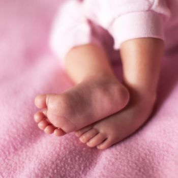 Little sweet legs of baby girl on pink background. Concept: kids, parenthood, family, baby shower. Square format for social media. Selective focus. Close-up