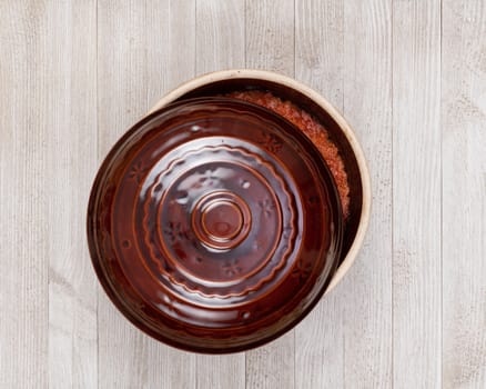 A ceramic pot of traditional Eastern European stewed cabbage on a white wooden kitchen board.