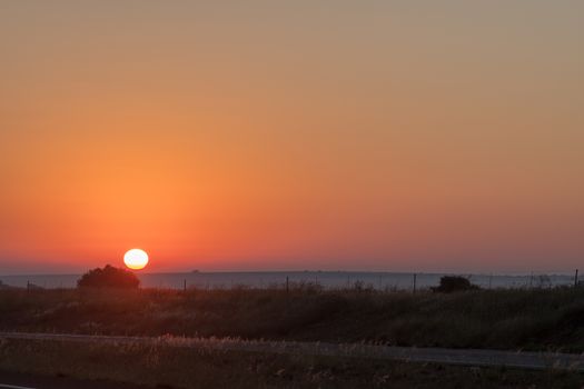 The sun is rising over road N1 just north of Bloemfontein, South Africa