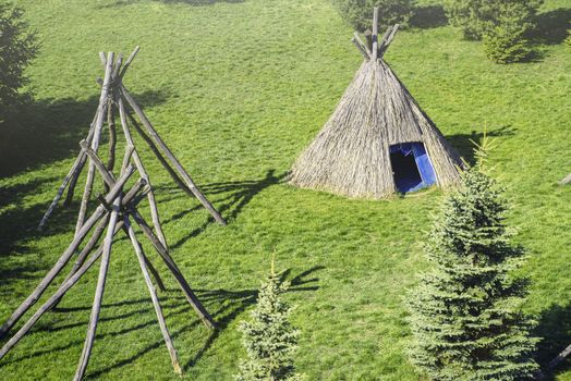 Wigwam type thatch huts .Straw wigwam on a glade on a sunny spring day.wigwam type thatch huts in native american camp site