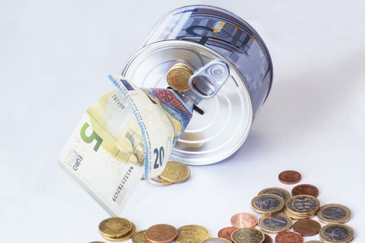 TFinancial risk and safety concept.he concept of money. A piggy bank in the form of a tin can and, next to the piggy bank, money bills and coins are laid out.