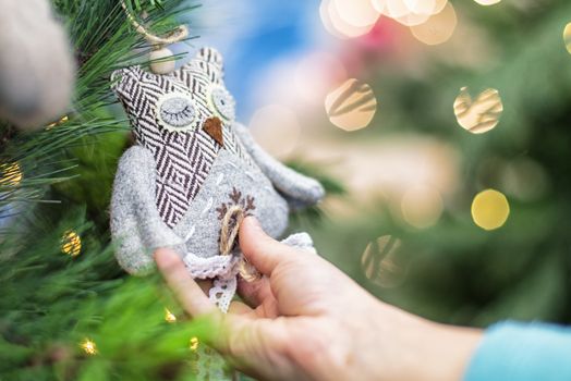 Christmas toy in the hands of a child.Children hands hold the decor at the Christmas tree on which the New Year's toys are hanging . Xmas concept.