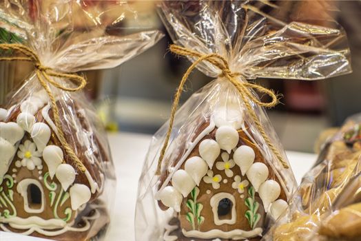 Gingerbread house wrapped. Lots of gingerbread houses.Homemade Christmas Gingerbread House displayed on a table.
