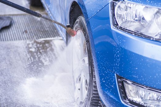 Cleaning Car Using High Pressure Water.Manual car wash with pressurized water in car wash outside.