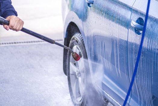 Cleaning Car Using High Pressure Water.Manual car wash with pressurized water in car wash outside.