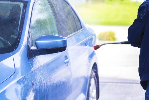 Cleaning Car Using High Pressure Water.Manual car wash with pressurized water in car wash outside.