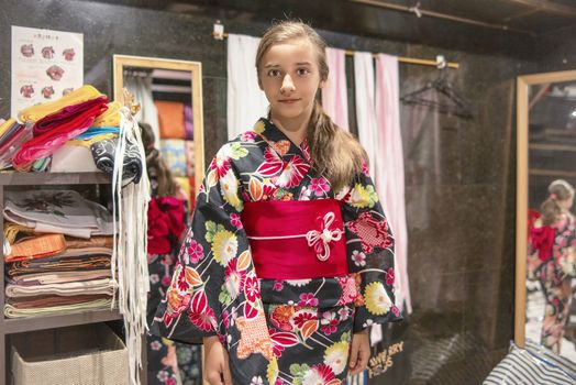 A pretty girl in a kimono. Kimono is the traditional dress worn popular in Japan.European girl in kimono.Portrait of girl wearing japanese traditional kimono .