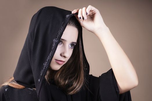 Arab saudi emirates woman face looking at side on a light background.Arab ,muslim,girl closeup on a light background.Muslim.