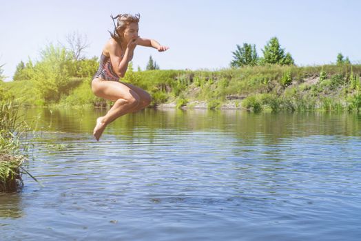 little girl running through the water with a splash . in her hands cloth.