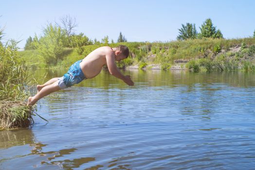 ?an jumps like fish into the water of the lake, swims, enjoys spending time on summer holidaysA fat man jumping on a summer day into a river with a run up.