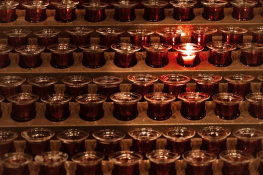 Many candle flames glowing in the dark.Candles in the church.