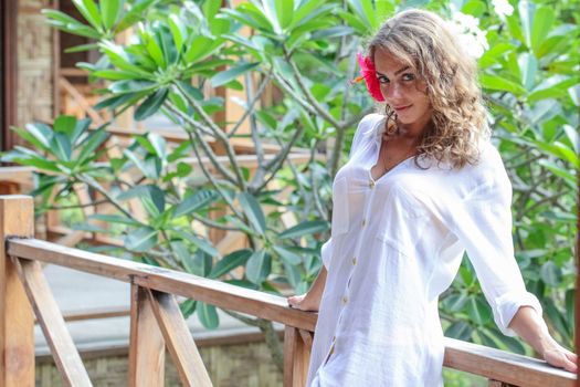 Woman posing in white shirt in tropical resort