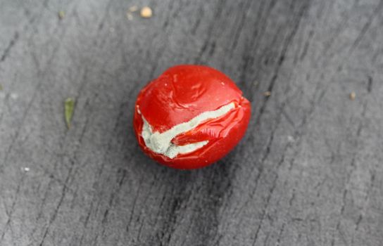 close up of Rotten cherry tomato on black cutting board background