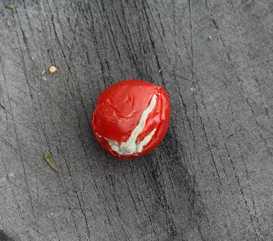 close up of Rotten cherry tomato on black cutting board background