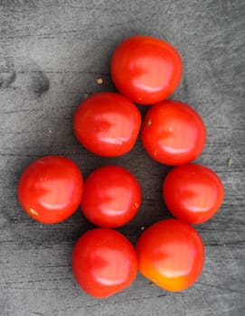 Close up of Fresh red cherry tomato on black cutting board background