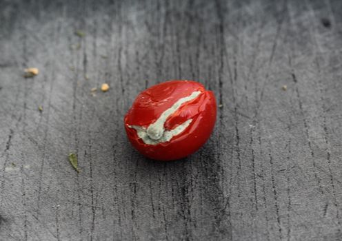 close up of Rotten cherry tomato on black cutting board background