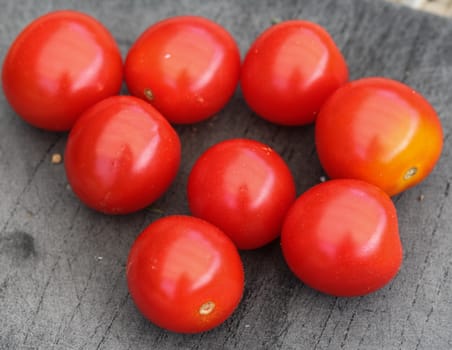 Close up of Fresh red cherry tomato on black cutting board background