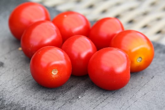 Close up of Fresh red cherry tomato on black cutting board background