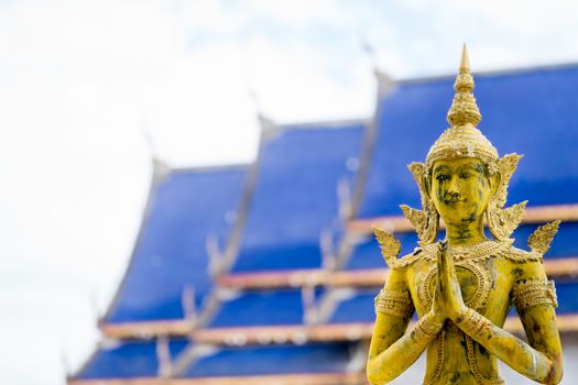 Angels statue to pay respect in blue roof and white sky background at Chiang Mai Thailand temple. Concept of Thai buddhism religion and culture.