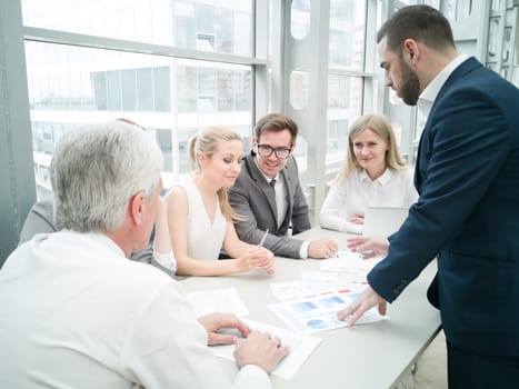 Group of business people discussing diagrams in office together